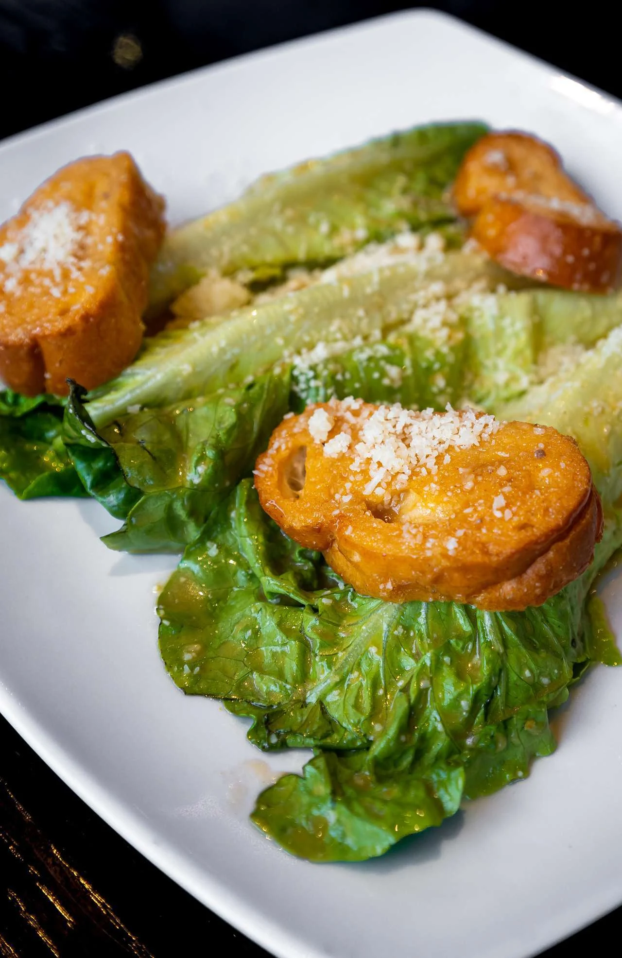 Ensalada César con hojas de lechuga, queso y pan dorado